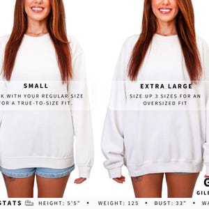 May include: A white Gildan 18000 crewneck sweatshirt shown in size small and extra large. Text reads: SMALL, STICK WITH YOUR REGULAR SIZE FOR A TRUE-TO-SIZE FIT; EXTRA LARGE, SIZE UP 3 SIZES FOR AN OVERSIZED FIT; FIT GUIDE GILDAN 18000; MODEL STATS HEIGHT: 5'5" WEIGHT: 125 BUST: 33" WAIST: 27".