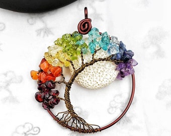 May include: A wire-wrapped tree of life pendant with a white coral center and rainbow colored gemstones. The pendant is made with copper wire and features a variety of gemstones, including amethyst, citrine, carnelian, and green aventurine. The pendant is a beautiful and unique piece of jewelry that would make a great gift for any occasion.