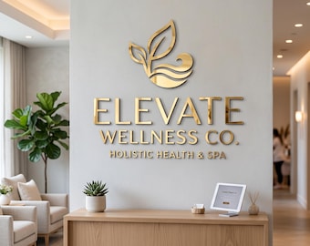 May include: A wall-mounted sign featuring the gold-colored text ELEVATE WELLNESS CO. HOLISTIC HEALTH & SPA with a stylized leaf logo above it. The sign is centered on a light gray wall above a wooden reception desk in a professional space.