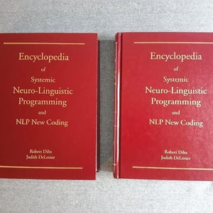 以下が含まれることがあります： ロバート・ディルツとジュディス・デロジエによる「Encyclopedia of Systemic Neuro-Linguistic Programming and NLP New Coding」というタイトルの2冊の赤いハードカバー本。テキストは金色の文字です。