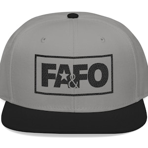 May include: A gray flat-brimmed baseball cap with a black brim and a black button on top. The front of the cap features the letters "FAFO" in a black rectangular box, with a star and ampersand symbol between the letters.