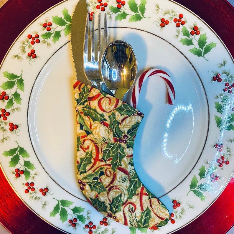 Christmas Sock Silverware Holder in a Holly Print with a Red Ribbon on Cream background image 1