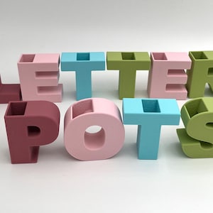 Macetas de almacenamiento de escritorio Mini LetterPots. Úsalas como florero para colocar algunas flores o como decoración o exhibición con muchas palabras.