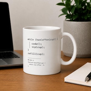 Puede incluir: Una taza de cerámica blanca con código de programación impreso en negro que dice while (hasCoffee(cup)) { code(); sip(cup); } refill(cup); e incluye un fragmento de función index.js más pequeño en la parte inferior, con un asa curva.