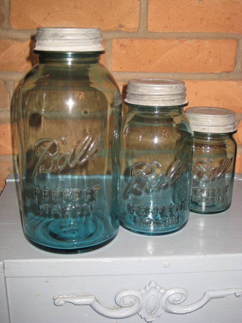 May include: Three glass Ball brand mason jars with silver lids. The largest jar is blue and says 'Perfect Mason' on the side. The middle jar is blue and says 'Perfect Mason' on the side. The smallest jar is blue and says 'Perfect Mason' on the side.