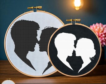 Puede incluir: Dos patrones de punto de cruz con la silueta de una pareja en forma de corazón. Un patrón es negro sobre blanco, y el otro es blanco sobre negro.