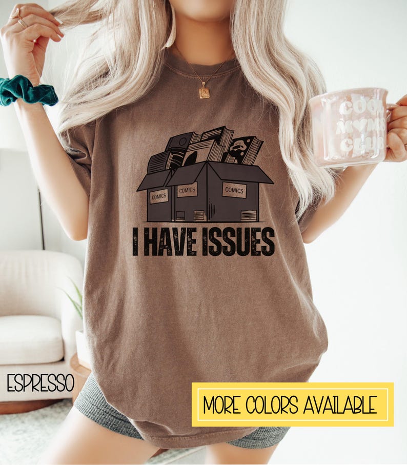 May include: A brown t-shirt with a graphic of a box filled with comic books and the text "I HAVE ISSUES".