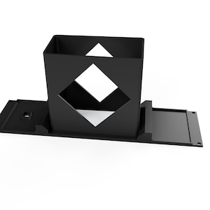 May include: A black, geometric, open-top box with a diamond-shaped cutout on the front. The box sits on a rectangular base with a sliding tray. The design is modern and minimalist.