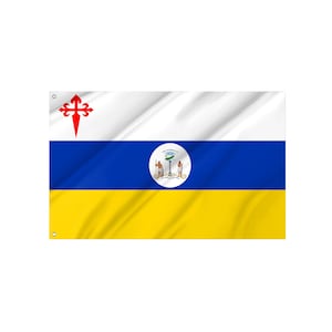 Op de afbeelding: Een rechthoekige vlag met drie horizontale banen in wit, blauw en geel. De bovenste witte baan toont links een rood Sint-Jakobskruis. De middelste blauwe baan bevat een cirkelvormig embleem met twee figuren en een zuil in het midden.