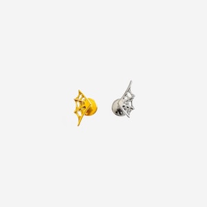 May include: Two stud earrings shaped like bat wings with a webbed design. One earring is finished in a bright gold tone, while the other is finished in a polished silver tone. Each piece features a flat circular backing for secure attachment.