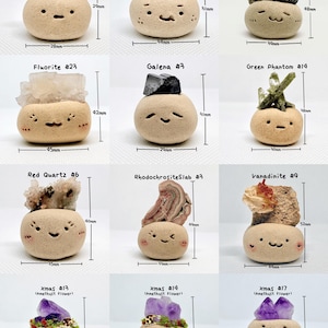 May include: A collection of whimsical, beige ceramic figures, each topped with a different type of mineral or crystal. Measurements in millimeters are included. The figures have smiling faces and are labeled with mineral names and numbers.