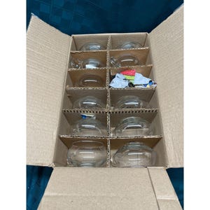May include: A box of 12 clear glass cups, packaged in individual compartments. The cups are round and have a slight curve at the top.