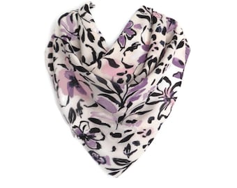 May include: A white scarf with a floral and animal print design. The flowers are purple and pink, and the animal print is black and white.