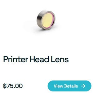 May include: A printer head lens with a silver metal casing and a yellow center. The lens has a circular shape and is designed for use in printers. The text "Printer Head Lens" is below the lens.