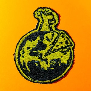 May include: Embroidered patch featuring a yellow pizza slice inside a black, round flask shape. The patch has a yellow border and is set against an orange background. The design is a playful take on a science lab flask.