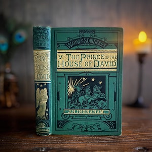 Könnte beinhalten: Ein antikes Buch mit dem Titel "The Prince of the House of David" mit grünem Einband und goldener Schrift. Das Buch gehört zur "Warne's Star Series". Das Cover zeigt eine Illustration von Figuren auf Pferden und den Namen des Autors, J.H. Ingraham.
