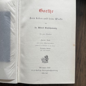 Puede incluir: P&aacute;gina de libro abierta con texto en alem&aacute;n. El t&iacute;tulo "Goethe" est&aacute; en escritura roja. El texto incluye "Sein Leben und seine Werke" y "Dr. Albert Bielschowsky". El libro es de 1908, publicado por C.H. Beck'sche Verlagsbuchhandlung.