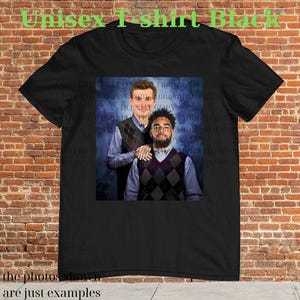 May include: Black unisex t-shirt featuring a photo of two people wearing argyle vests over button-down shirts. The text "Unisex T-shirt Black" is at the top, and "the photos shown are just examples" is at the bottom.