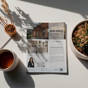 May include: A real estate flyer with the headline "JUST SOLD" and a photo of a modern home. The flyer includes photos of the home's interior, a real estate agent's photo, and contact information. A cup of coffee and a potted plant are also visible.