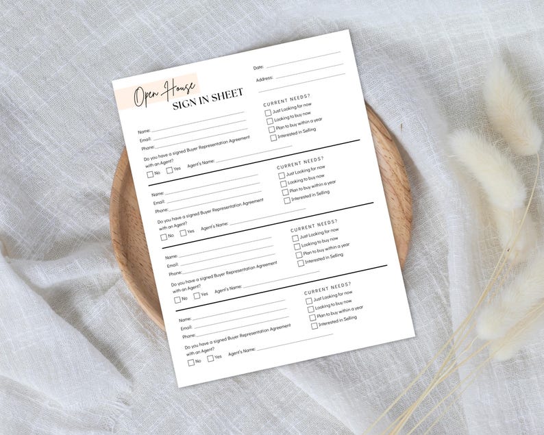May include: A white Open House Sign In Sheet with black text, including fields for name, email, and phone. The sheet also includes checkboxes for current needs and buyer representation agreement. The sheet is on a wooden plate.