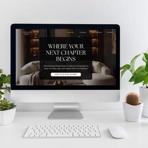 May include: A computer monitor displaying a real estate website with the text WHERE YOUR NEXT CHAPTER BEGINS and START YOUR HOME JOURNEY. The screen shows a living room interior, and the monitor is surrounded by several small potted plants.
