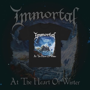 May include: Black t-shirt with the band name "Immortal" in white gothic lettering and a winter landscape graphic. The text "At The Heart Of Winter" is below the graphic. The background has a dark blue and white winter theme.