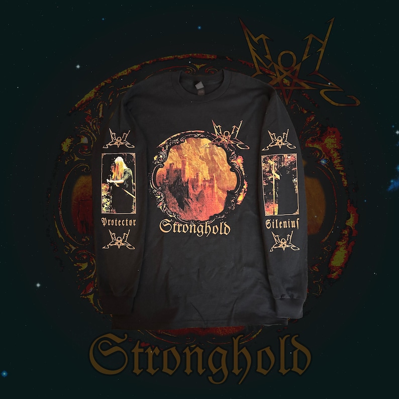 May include: Black long-sleeve shirt with a circular graphic featuring a cityscape in shades of orange and yellow. The word "Stronghold" is below the graphic. Sleeves have additional graphics and the words "Protector" and "Silenius".