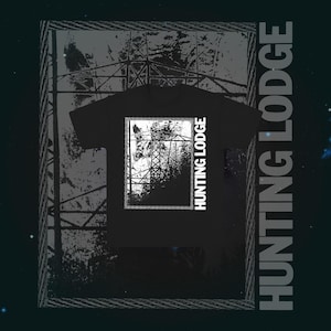May include: Black t-shirt featuring a white graphic of a power line tower and the text "HUNTING LODGE" in a vertical font. The background has a dark, textured design.