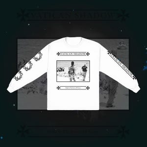 Könnte beinhalten: Weißes Langarmshirt mit einem Schwarz-Weiß-Bild von zwei Personen in einer verschneiten Landschaft. Das Shirt zeigt den Text "VATICAN SHADOW" auf der Vorderseite und den Ärmeln sowie "Made In The Service Of Terror" am unteren Rand.