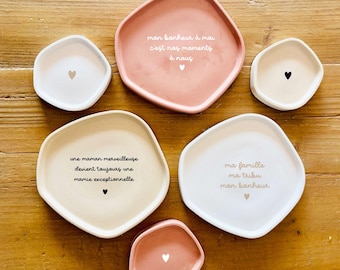May include: Five different sized, irregular shaped concrete trays with various sayings in French. The trays are in shades of pink and white with a heart design on each.