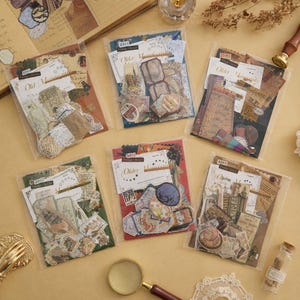 May include: Six clear plastic packets containing assorted paper ephemera, including vintage-style labels, postcards, and decorative cutouts. Each packet features a header card labeled Old Manuscripts or Vintage Classics with various printed designs.