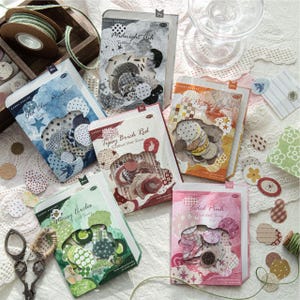 May include: Five rectangular paper sticker packs labelled Midnight Ash, Old Blue Print, Tipsy Brick Red, Old Paper Mellow, Mossy Circles, and Faded Pink. Each pack contains assorted circular paper cutouts with various patterns and colours.