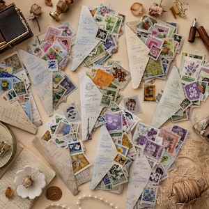 May include: A collection of vintage postage stamps featuring diverse botanical, floral, and scenic illustrations, organized within several triangular paper envelopes labeled with titles like Bluebird's Note, Postmark of Time, and Bloom Messages.
