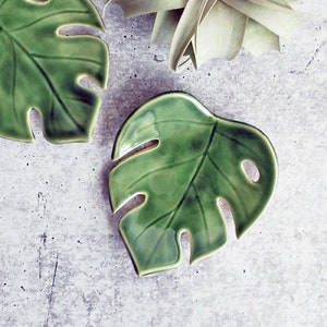 Green Monstera leaf shaped ceramic bowl. Has cutouts similar to a real Monstera leaf. Handmade by Lauren Sumner Pottery.