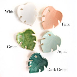 May include: Five ceramic monstera leaf dishes in different colors: white, pink, green, aqua, and dark green.