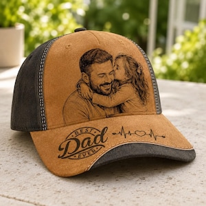 Puede incluir: Gorra de béisbol beige con visera y botón superior negros. La gorra presenta una imagen en blanco y negro de un padre y un niño. El texto "Best Dad Ever" está impreso en la parte delantera.