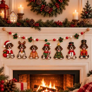 May include: A Christmas garland featuring seven hanging ornaments of brown and white dogs, each dressed in different holiday costumes including a Santa suit, reindeer antlers, gingerbread man, elf, Christmas tree, snowman, and nutcracker.