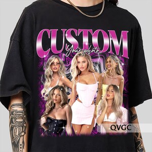 Pu&ograve; includere: Maglietta nera con una grafica rosa "CUSTOM Your Photo" che presenta quattro donne con lunghi capelli biondi. Le donne indossano abiti diversi, tra cui un top corto rosa, un corsetto nero, una canotta bianca e una canotta gialla. La grafica &egrave; su uno sfondo viola e bianco a spirale.