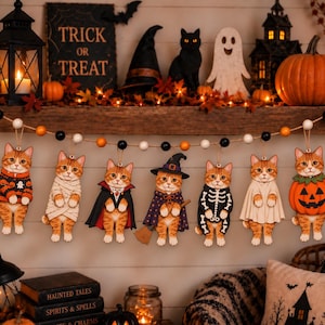 May include: A decorative garland featuring seven wooden orange tabby cat ornaments, each dressed in a different Halloween costume, including a pumpkin, ghost, skeleton, witch, vampire, mummy, and sweater, strung on a black, white, and orange bead cord.