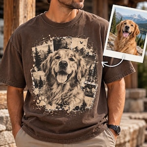 Może przedstawiać: Brązowy t-shirt z krótkim rękawem z nadrukiem graficznym przedstawiającym golden retrievera w otoczeniu kolażu scen leśnych i górskich, odciskiem łapy oraz małym wstawionym zdjęciem tego samego psa na tle górskiego krajobrazu.