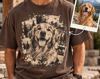 May include: A brown short-sleeve t-shirt featuring a graphic print of a golden retriever surrounded by a collage of forest and mountain scenes, a paw print, and a small inset photo of the same dog in a mountain landscape with a white border.