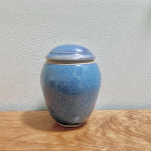 May include: A handmade, wooden cutting board with a natural finish. The board features a live edge on one side and a smooth, rectangular shape. It is approximately 18 inches long and 12 inches wide.