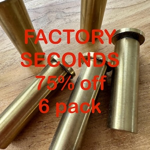 May include: Six gold-colored metal furniture legs, labeled "FACTORY SECONDS 75% off 6 pack".