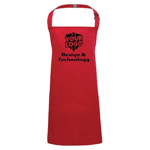 May include: A bright red apron featuring a black logo with the text "YOUR LOGO" above "Design & Technology". It has an adjustable neck strap and a buckle. The apron is made of a solid red fabric.