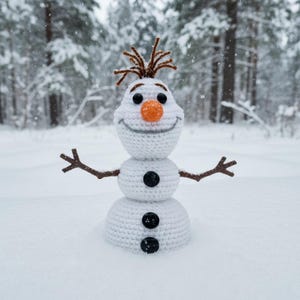 Peut inclure: Un bonhomme de neige crocheté avec un nez en carotte, des yeux en bouton noirs et des bras en brindilles se dresse dans la neige. Le bonhomme de neige a un visage souriant et des cheveux bruns. L'arrière-plan présente des arbres couverts de neige.