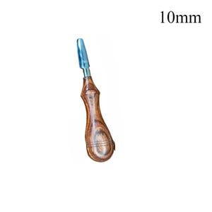 May include: A wood-handled tool with a blue tip, approximately 10mm in length. The handle has a curved design with visible wood grain. The tool appears to be a specialized instrument, possibly for crafting or repair.