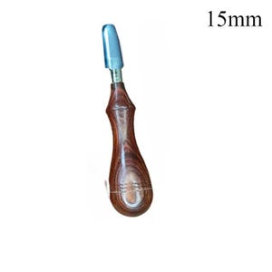 May include: A wood-handled tool with a silver-colored tip. The handle is a dark brown color with a curved, ergonomic design. The text "15mm" is visible in the upper right corner, indicating the tool's size.