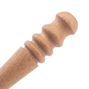 May include: A light brown wooden handle featuring a series of four rounded, horizontal ridges along its upper section. The wood grain is visible throughout the surface, and the top of the handle is rounded with a smooth, curved finish.