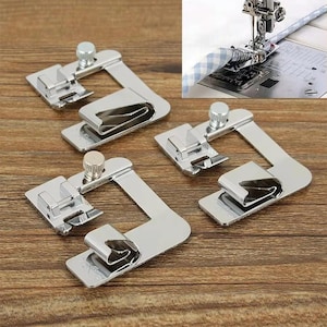 Pode incluir: Três calcadores de metal prateado para máquina de costura, destinados a bainhas, cada um com base plana, guia de bainha enrolada e parafuso de ajuste vertical. Um detalhe mostra um desses calcadores fixado a uma agulha.