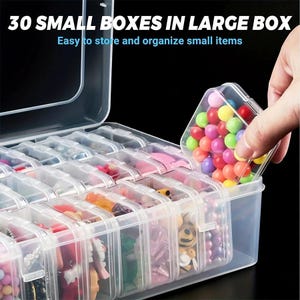 May include: A large clear plastic storage container holding 30 individual small clear boxes. The text 30 SMALL BOXES IN LARGE BOX is printed at the top. Each small box contains various colorful beads and small craft items for organization.